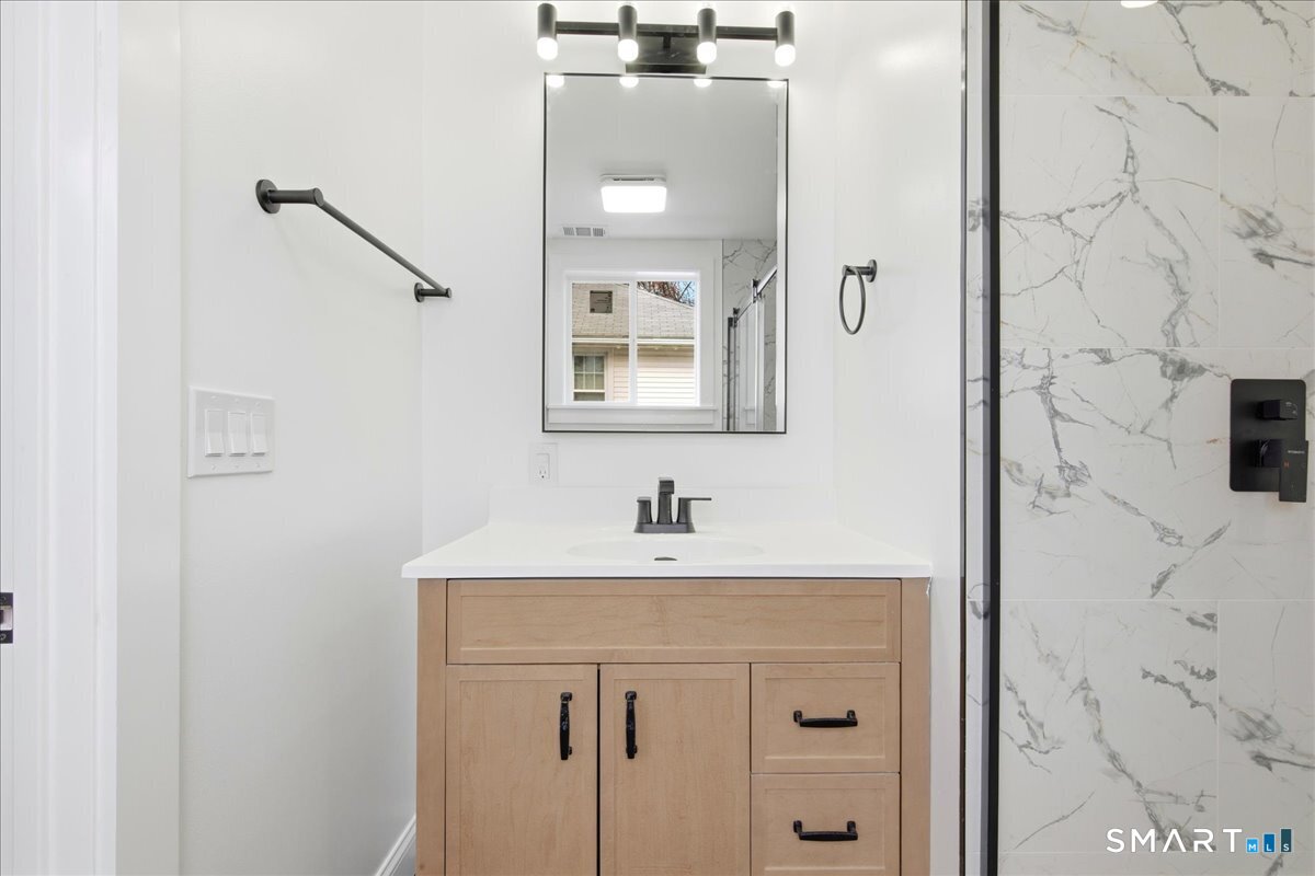 52 Coram Street Hamden, CT 06517 - Photo 32 of 40 a bathroom with a sink a vanity and a mirror