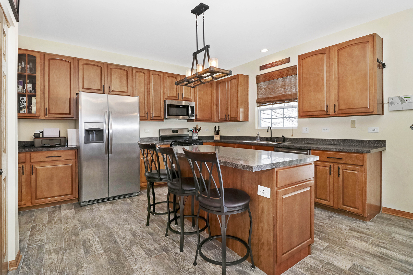428 Cardinal Lane Bolingbrook, IL 60490 - Photo 13 of 36 a kitchen with stainless steel appliances granite countertop a refrigerator a sink a stove a dining table and chairs