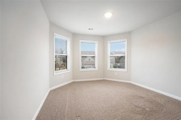 a spacious bedroom with a bed and a flat screen tv