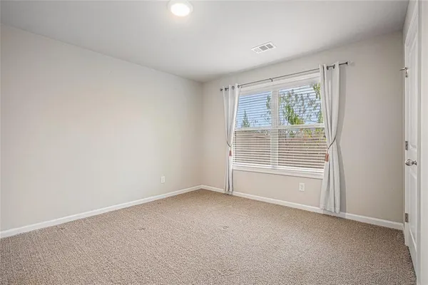 a spacious bedroom with a bed and a flat screen tv