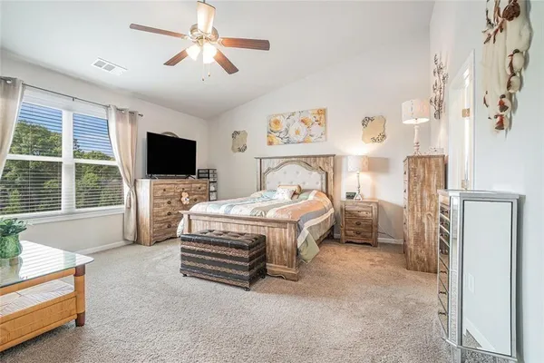 a view of an empty room with window and chandelier fan