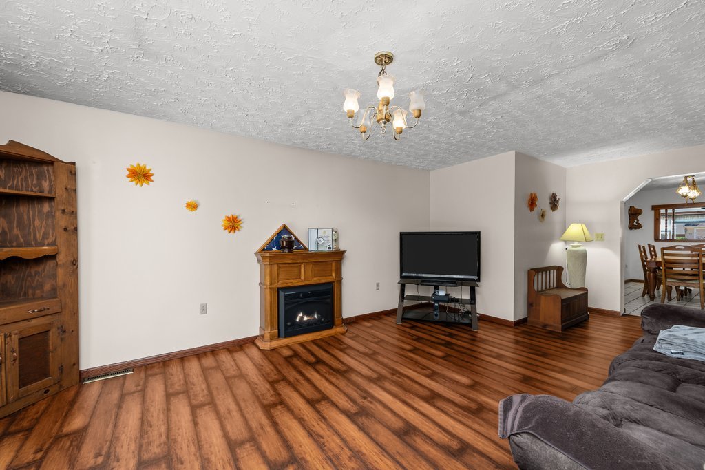 11213 22nd Street Milan, IL 61264 - Photo 21 of 36 a living room with furniture a fireplace and a flat screen tv