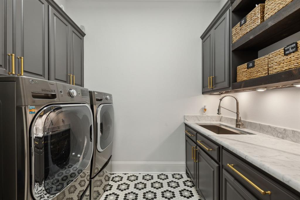 12444 Riverhill Road Frisco, TX 75033 - Photo 16 of 37 Laundry room with sink, marble countertops, washer and dryer, and lots of cabinets with undercounted lighting.
