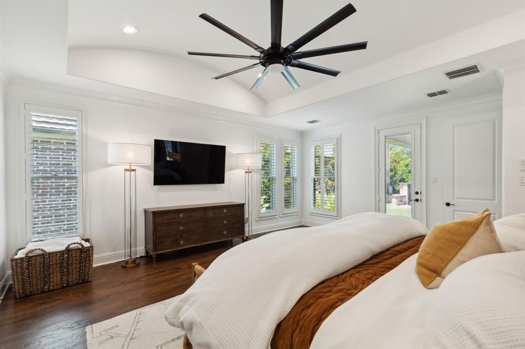 12444 Riverhill Road Frisco, TX 75033 - Photo 20 of 37 Master Bedroom featuring a tray ceiling, hardwood flooring, ceiling fan, plantation shutters and access to patio.