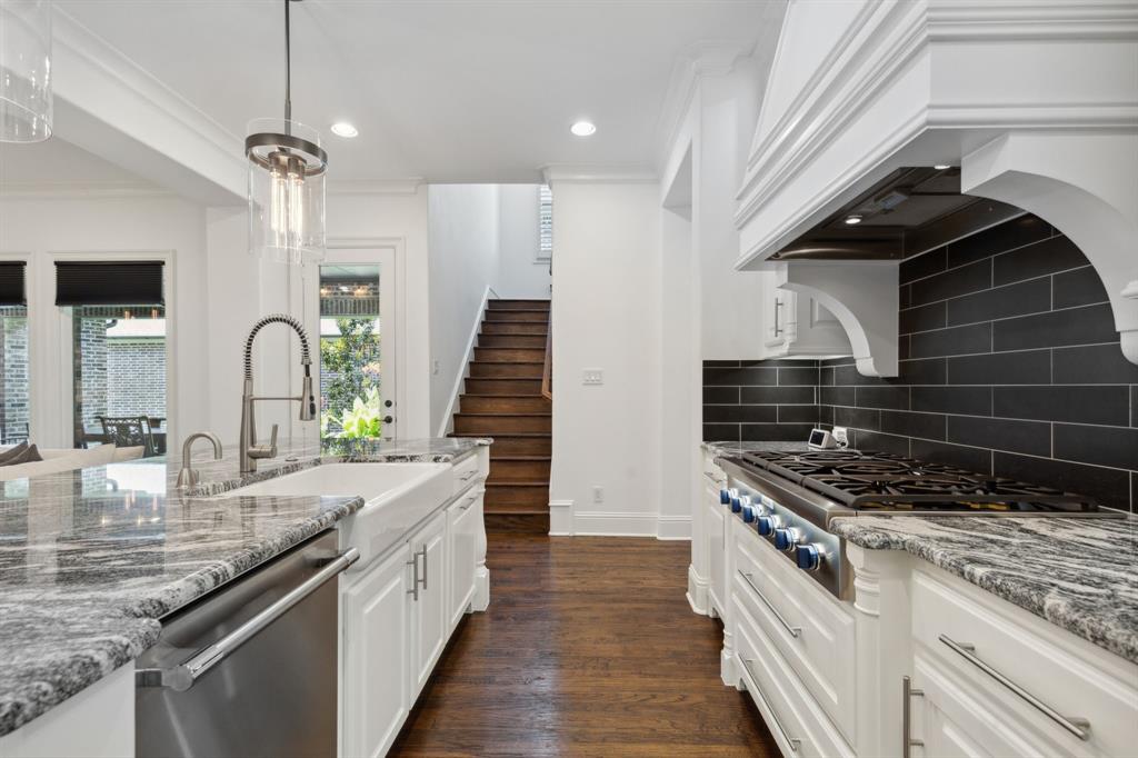 12444 Riverhill Road Frisco, TX 75033 - Photo 7 of 37 Kitchen with crown molding, Thermador stainless steel appliances, wood flooring, backsplash, and white cabinets