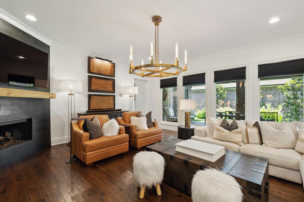 12444 Riverhill Road Frisco, TX 75033 - Photo 10 of 37 Living room featuring an inviting chandelier, hardwood flooring, ornamental molding, and a gas fireplace