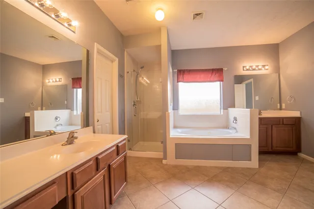 a spacious bathroom with a bathtub sink and mirror