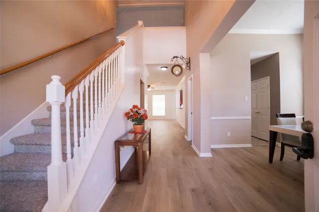 a view of a hallway with furniture and wooden floor