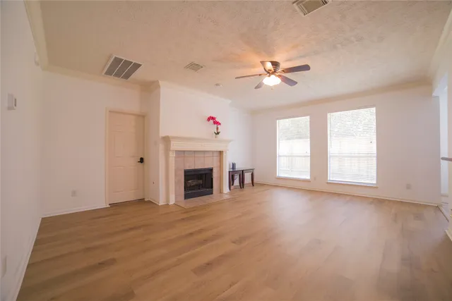 a view of empty room with wooden floor and fireplace