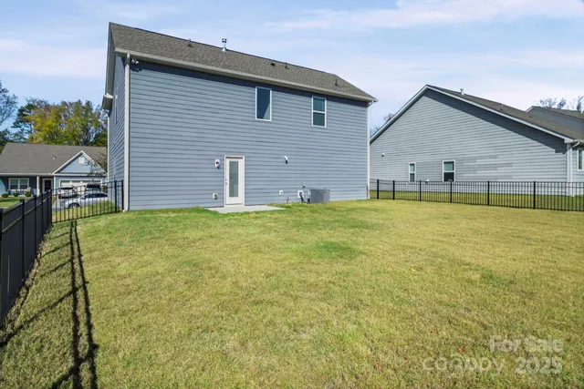 a view of a house with a yard and a large tree