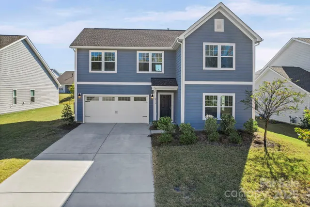 a front view of house with yard and green space