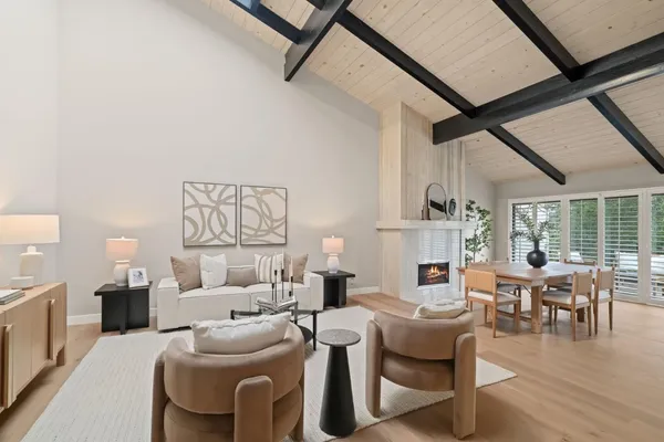 a living room with fireplace furniture and a large window