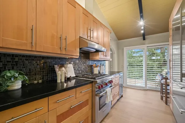 a kitchen with stainless steel appliances granite countertop a stove a sink and a microwave