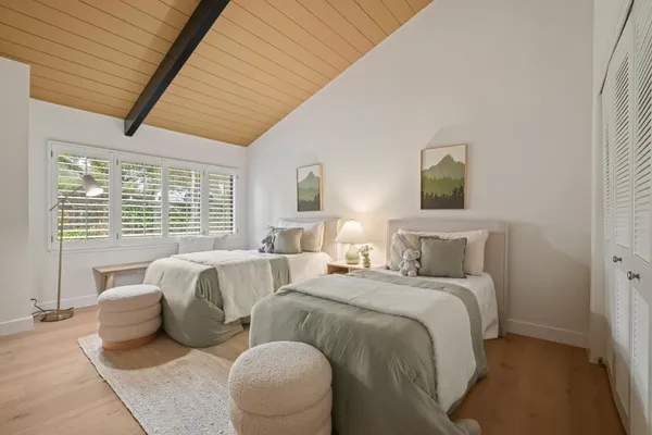 a spacious bedroom with two beds and a large window