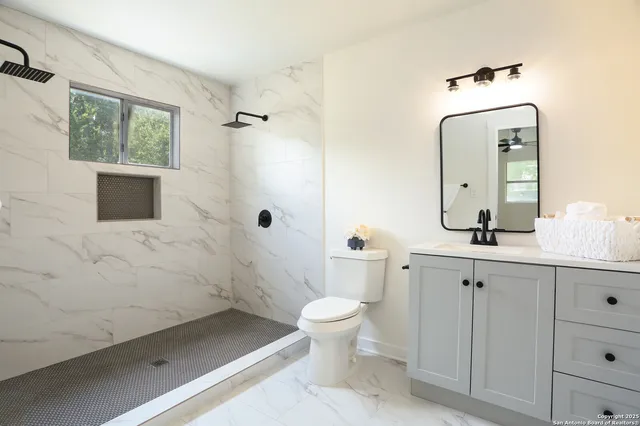 a bathroom with a sink a toilet and shower