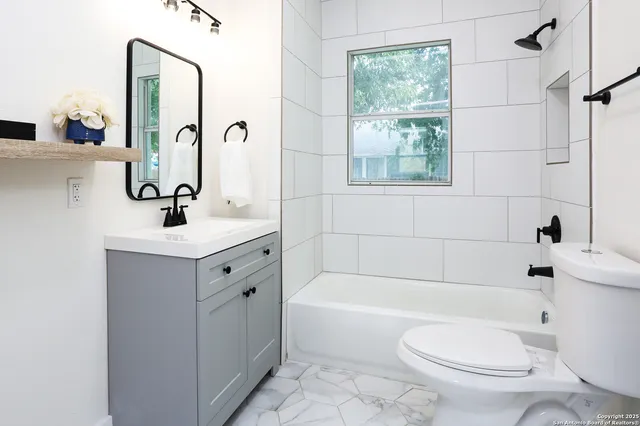 a bathroom with a sink a toilet and shower