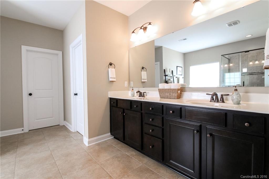 662 Reliance Court, Unit 13 Tega Cay, SC 29708 - Photo 17 of 24 a spacious bathroom with a double vanity sink a mirror and a shower