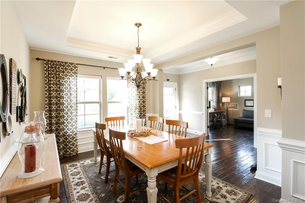 662 Reliance Court, Unit 13 Tega Cay, SC 29708 - Photo 5 of 24 a view of a dining room and livingroom with furniture wooden floor a chandelier