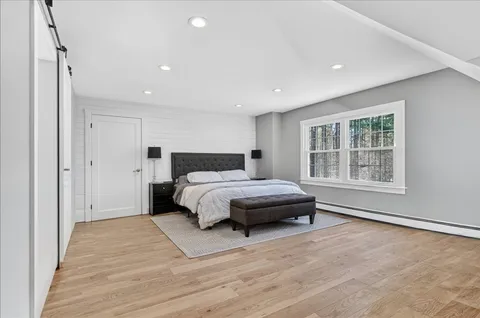 a spacious bedroom with a bed and a window
