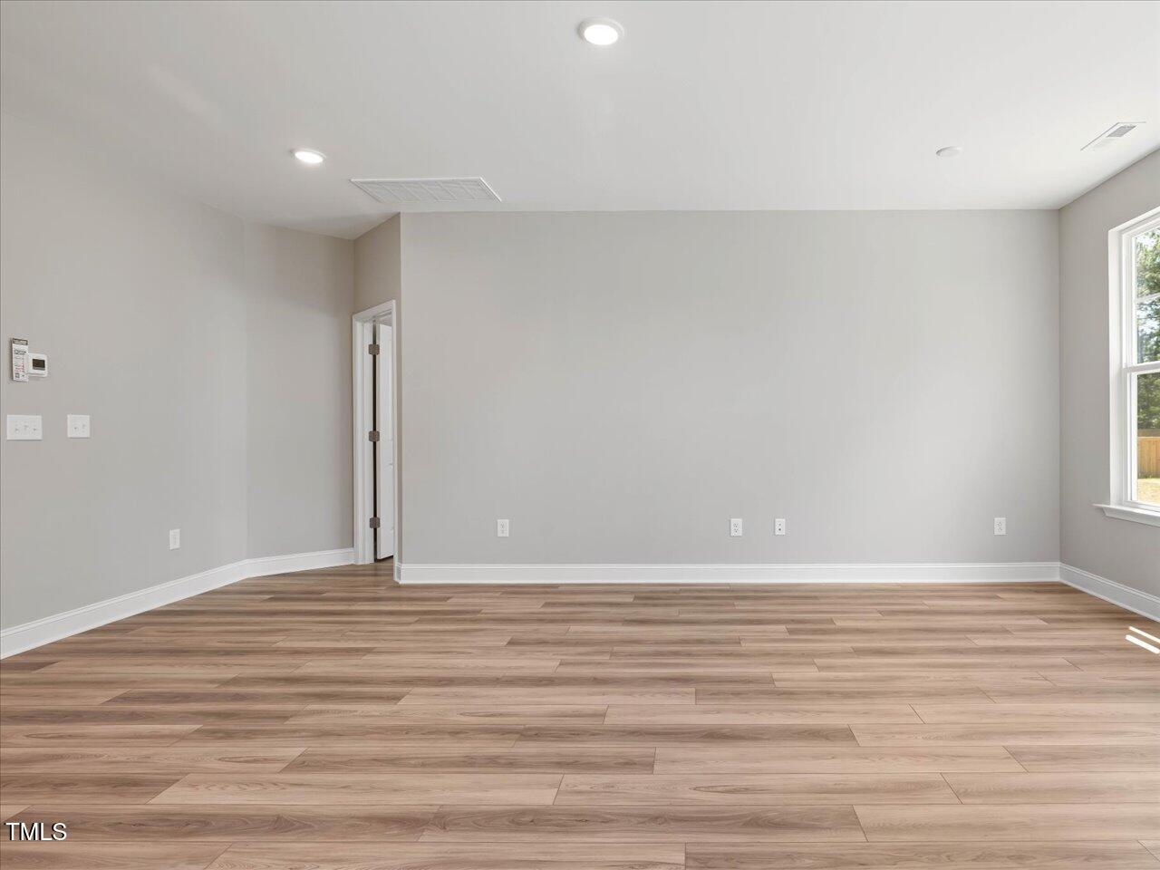 63 Biscayne Court Angier, NC 27501 - Photo 15 of 52 a view of an empty room with wooden floor and a window