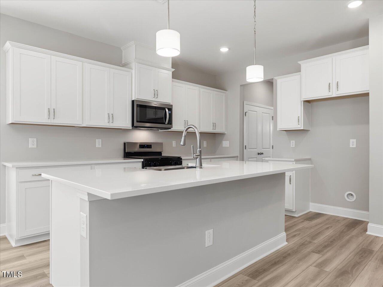 63 Biscayne Court Angier, NC 27501 - Photo 17 of 52 a kitchen with stainless steel appliances a stove a sink and white cabinets
