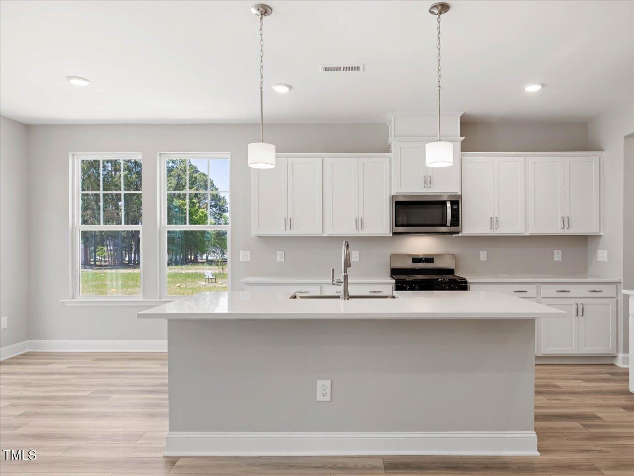 63 Biscayne Court Angier, NC 27501 - Photo 19 of 52 a kitchen with stainless steel appliances granite countertop a stove a sink and a white cabinets