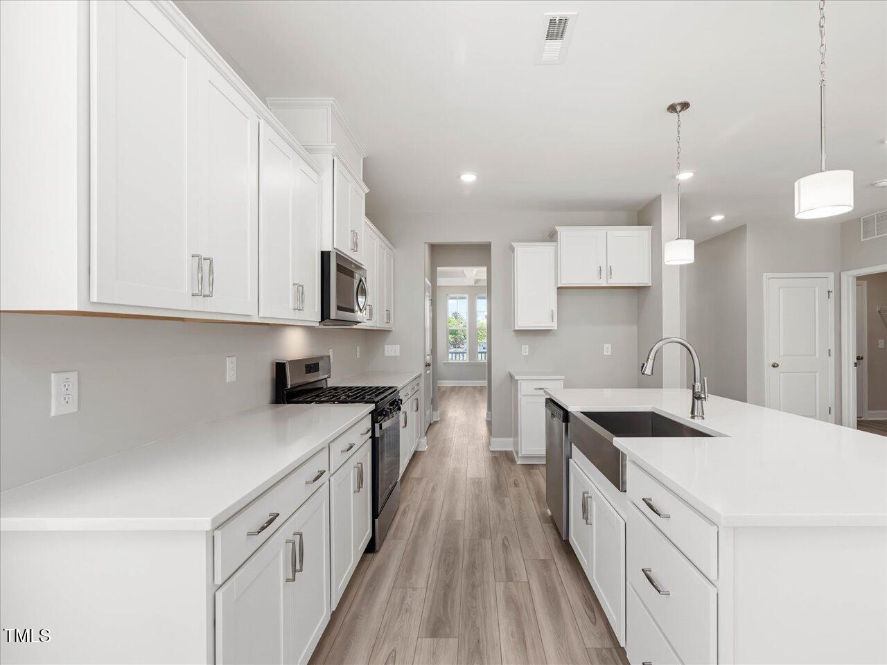 63 Biscayne Court Angier, NC 27501 - Photo 20 of 52 a kitchen with granite countertop a sink a stove oven a counter space and cabinets