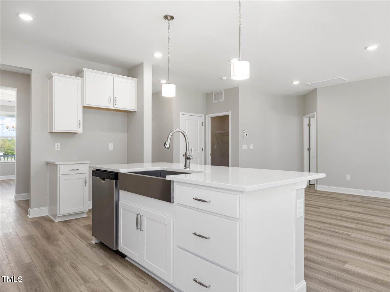 63 Biscayne Court Angier, NC 27501 - Photo 21 of 52 a large white kitchen with a large island oven a sink stainless steel appliances and cabinets
