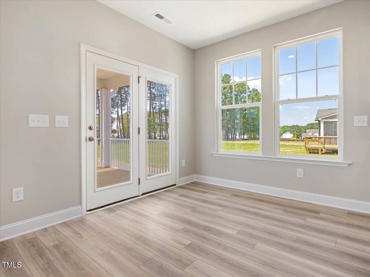 63 Biscayne Court Angier, NC 27501 - Photo 25 of 52 a view of an empty room with wooden floor and windows