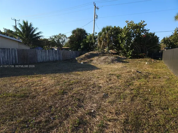 a view of a yard with wooden fence