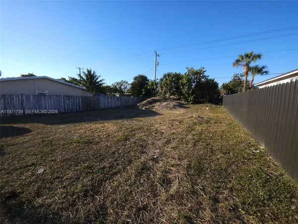 a view of a yard with wooden fence