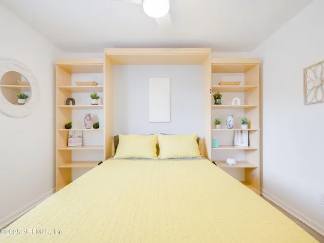 a bedroom with a bed and a painting on the wall