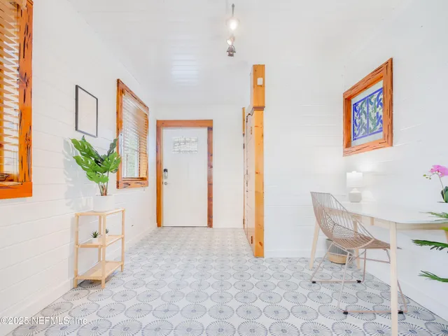 a view of a hallway with furniture and a potted plant