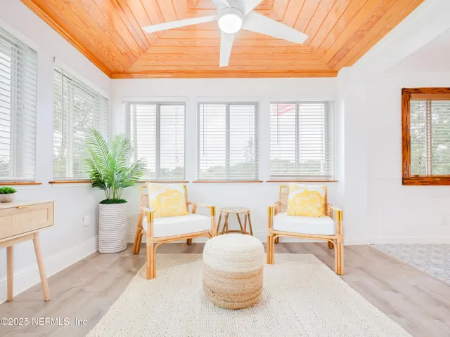 a living room with furniture and floor to ceiling windows