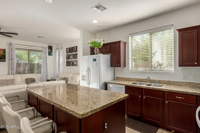 a kitchen with granite countertop a sink and a refrigerator