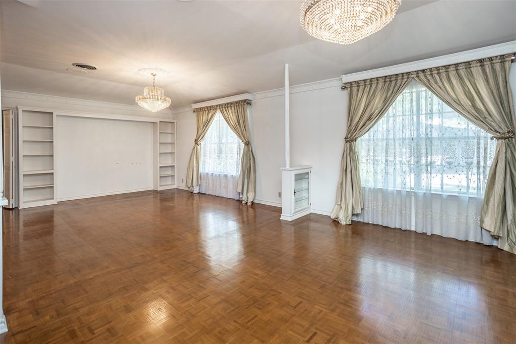 1010 Aspen Road Gainesville, TX 76240 - Photo 22 of 40 an empty room with wooden floor chandelier and windows