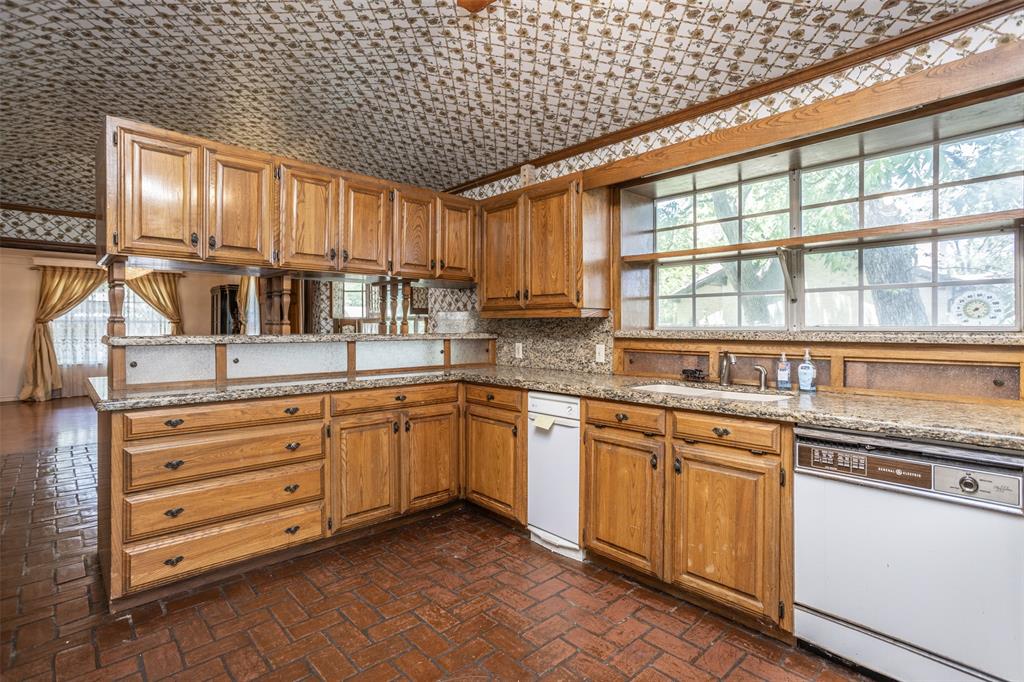 1010 Aspen Road Gainesville, TX 76240 - Photo 25 of 40 a kitchen with granite countertop white cabinets and white appliances