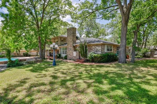 a view of a house with swimming pool and a trees
