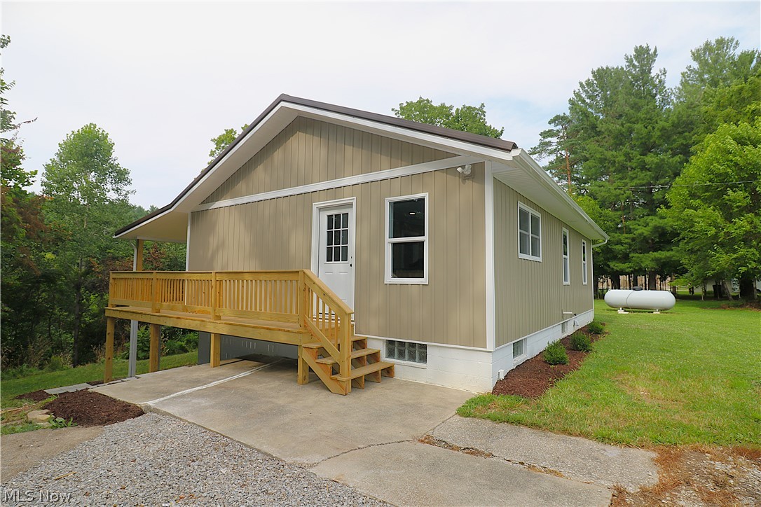 5236 Zenobia Road Wakeman, OH 44889 - Photo 26 of 31 Tan vertical siding exterior featuring white trim and a dark roof