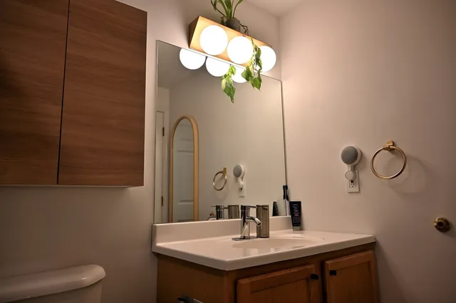 a bathroom with a sink a toilet and mirror