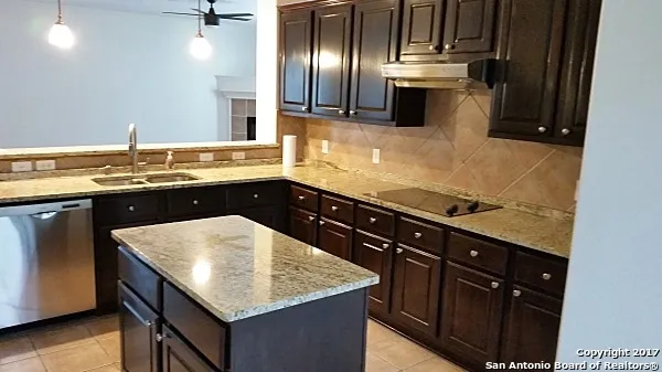 a view of an empty room with wooden floor fireplace and a window