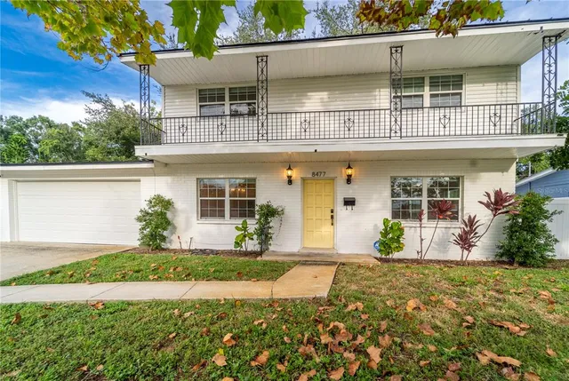 a front view of a house with a yard and trees