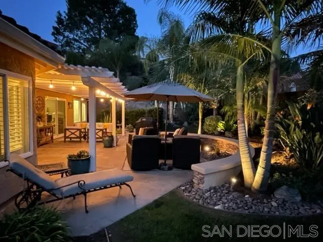 3330 Vista Rocosa Escondido, CA 92029 - Photo 29 of 29 a view of a patio with couches table and chairs under an umbrella with a fire pit