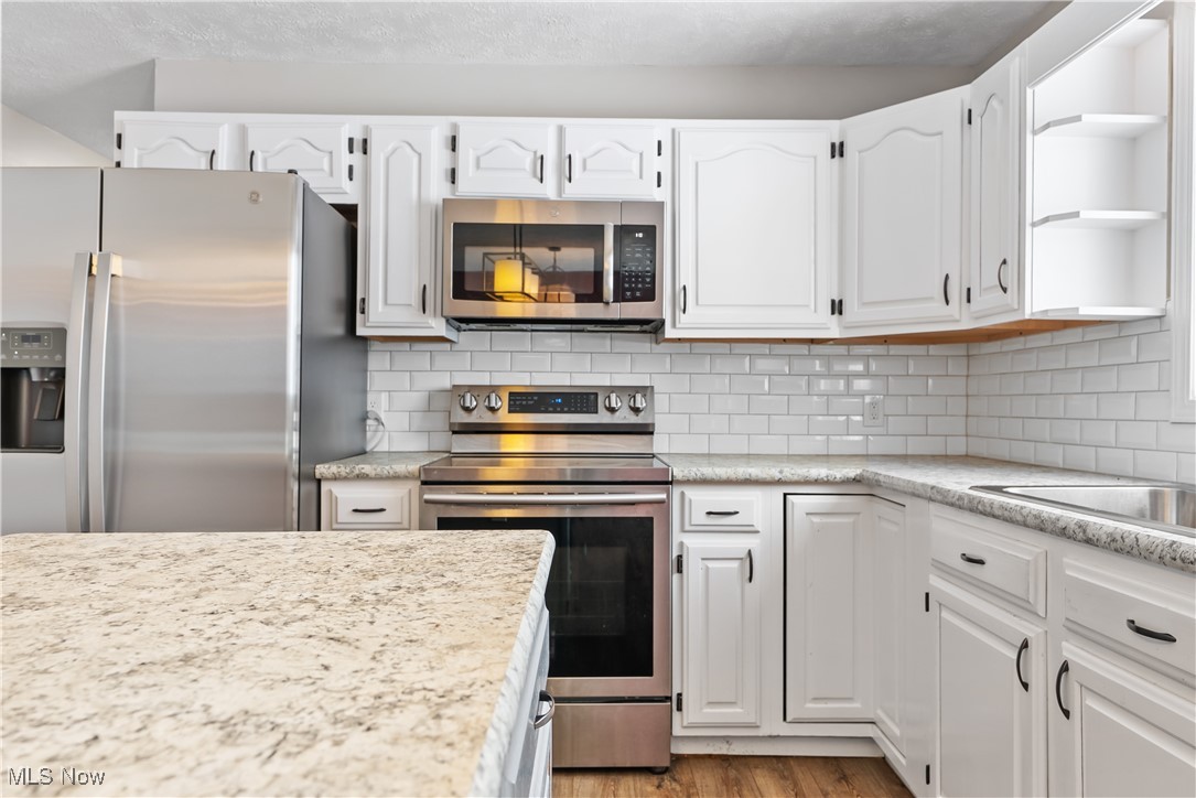 6059 Branch Road Medina, OH 44256 - Photo 13 of 39 Kitchen with white cabinetry, appliances with stainless steel finishes, open shelves, and decorative backsplash
