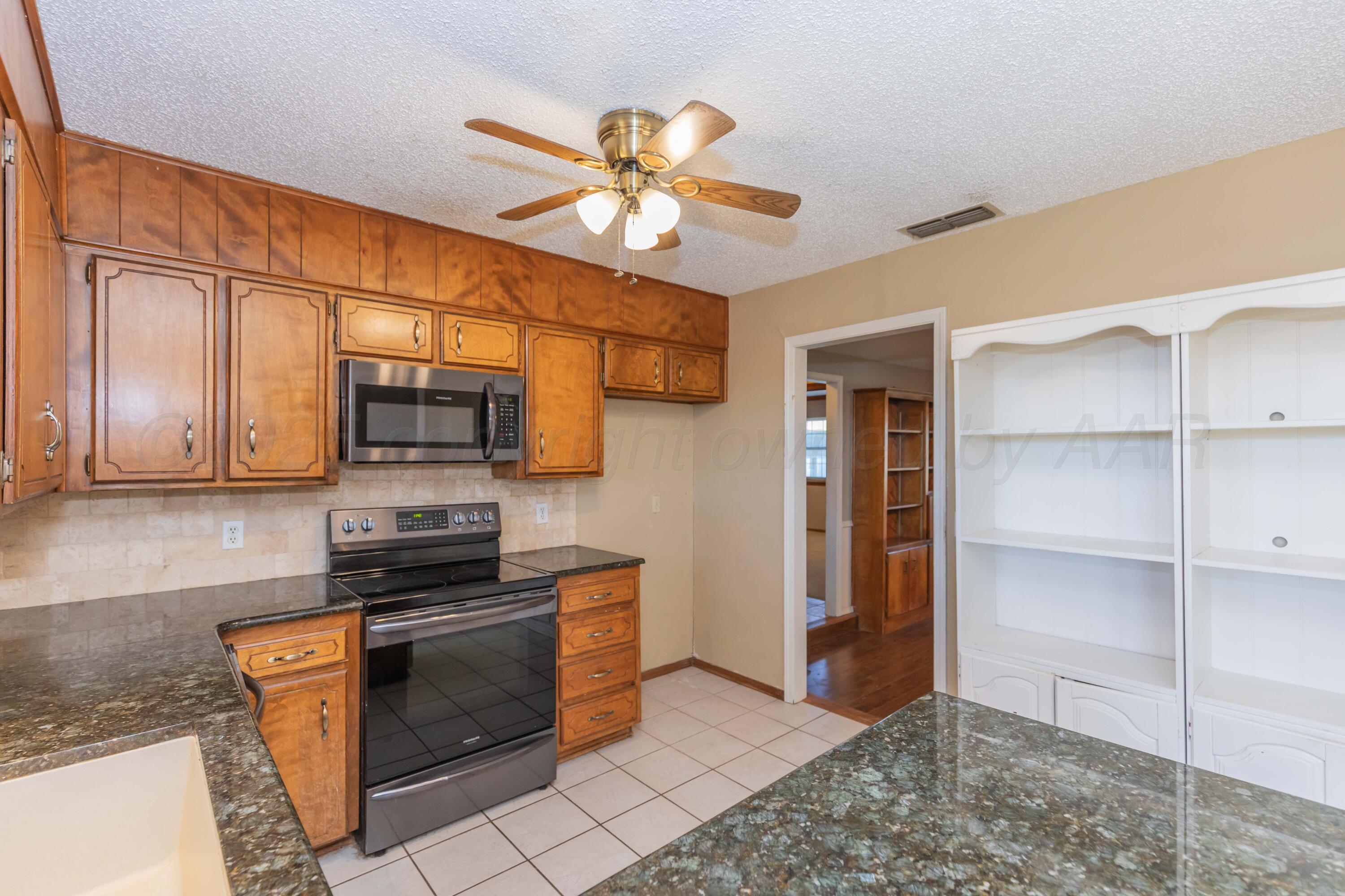 134 Eddie Street Canadian, TX 79014 - Photo 11 of 45 a kitchen with stainless steel appliances a stove a microwave and cabinets
