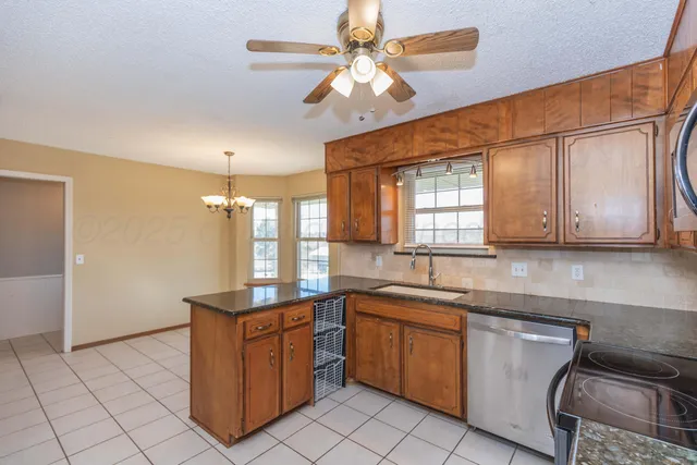a kitchen with stainless steel appliances granite countertop a stove a sink and a refrigerator
