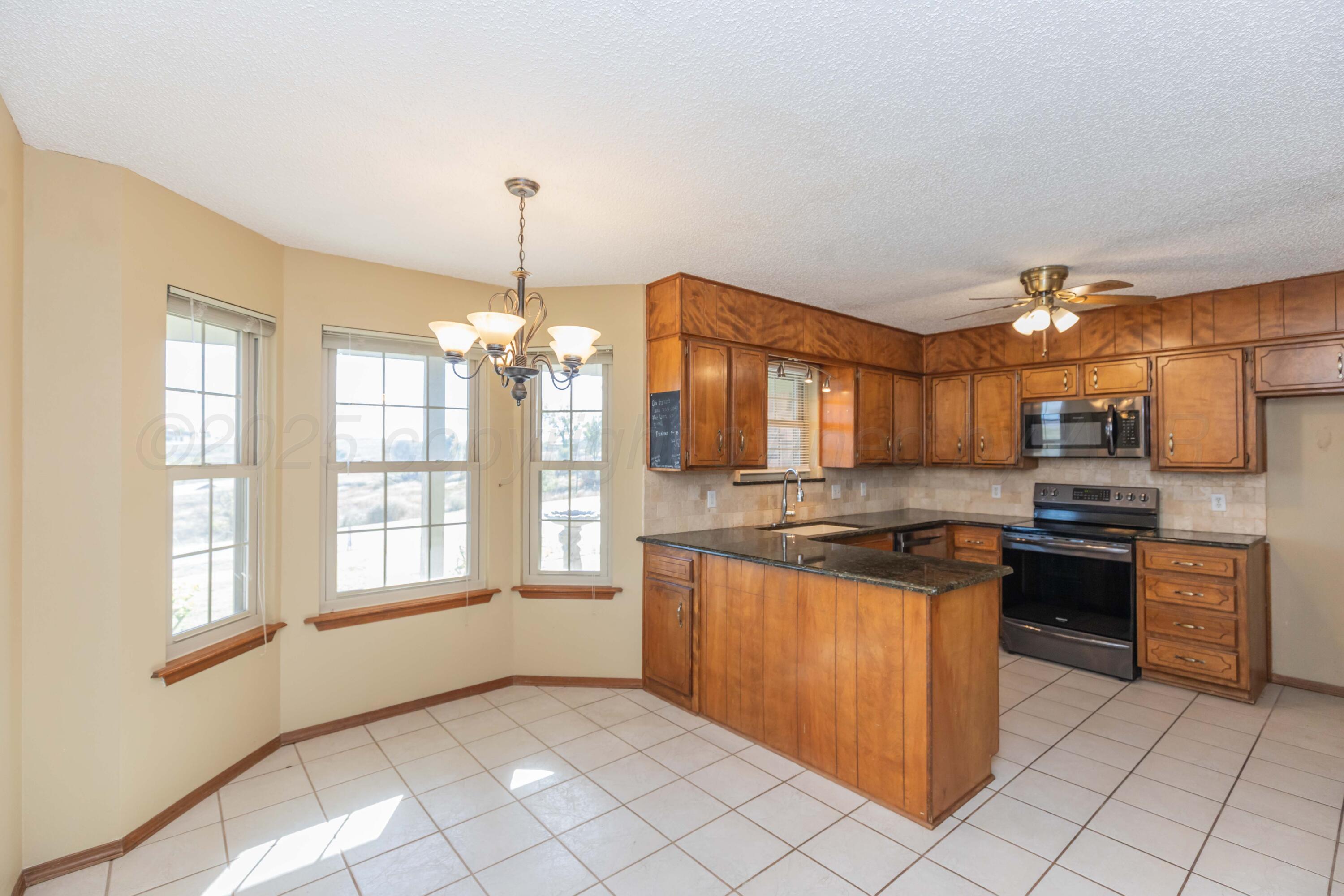 134 Eddie Street Canadian, TX 79014 - Photo 15 of 45 a kitchen with stainless steel appliances granite countertop a stove a sink and a refrigerator