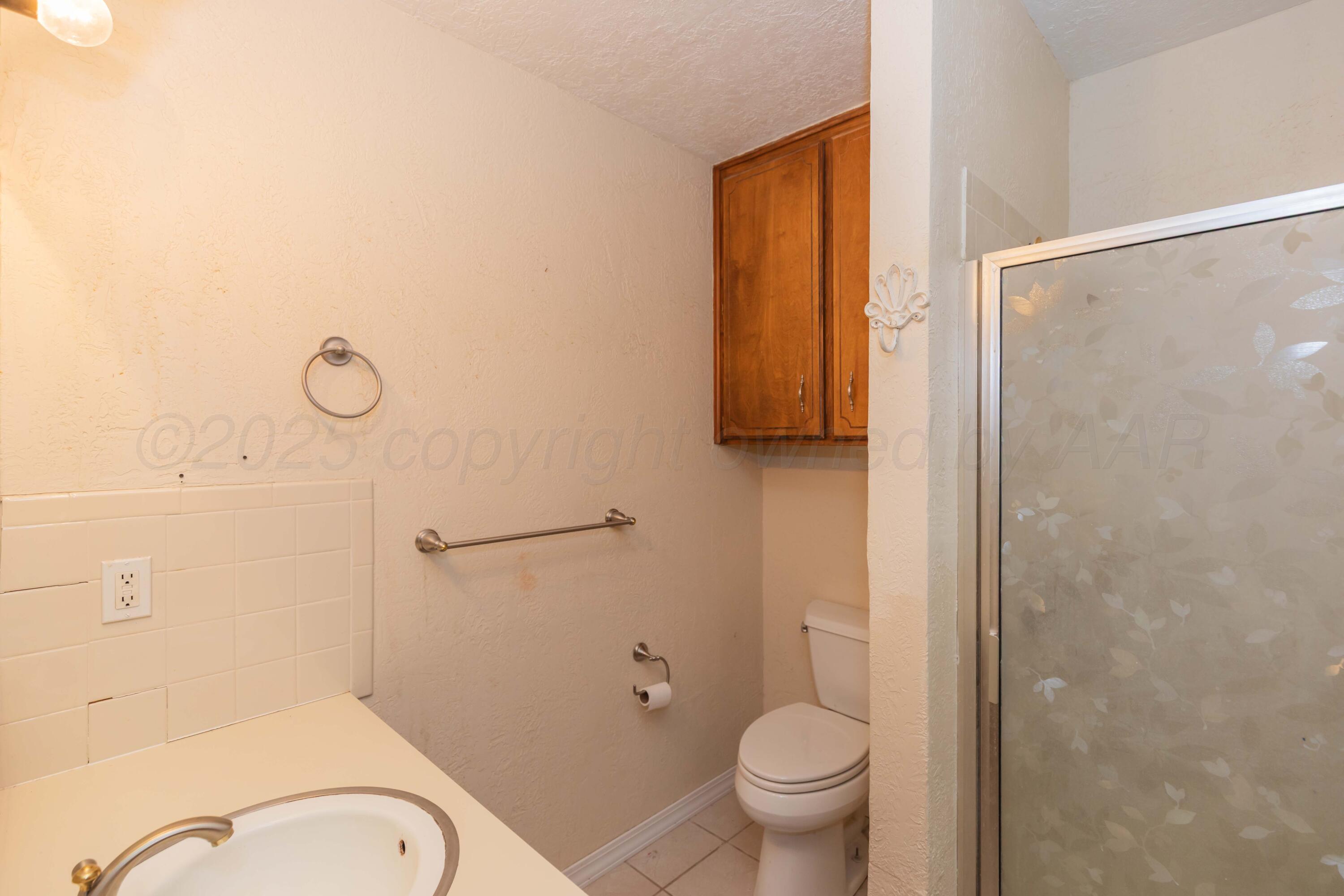 134 Eddie Street Canadian, TX 79014 - Photo 22 of 45 a bathroom with a granite countertop sink toilet and shower