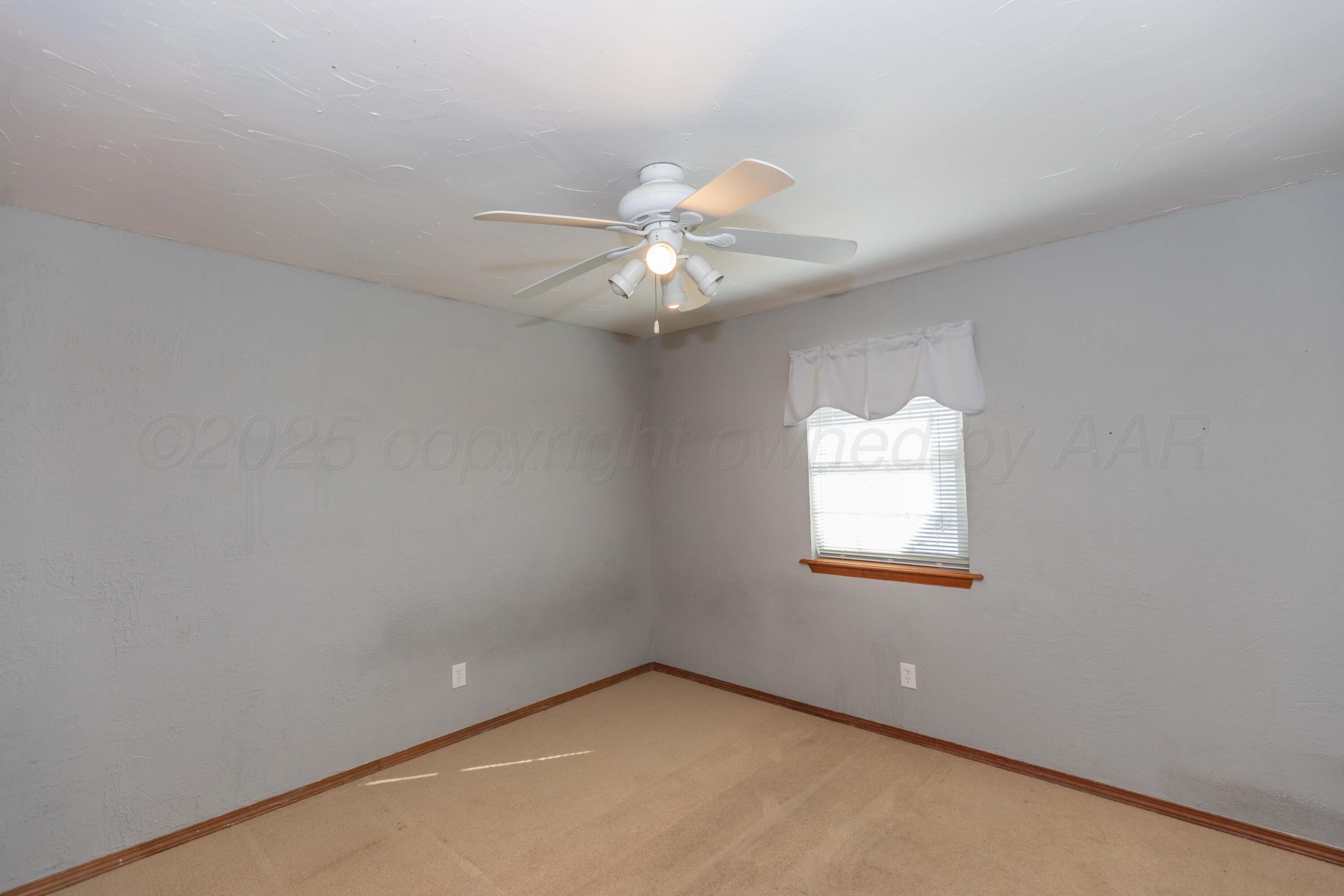 134 Eddie Street Canadian, TX 79014 - Photo 23 of 45 an empty room with windows and a chandelier fan