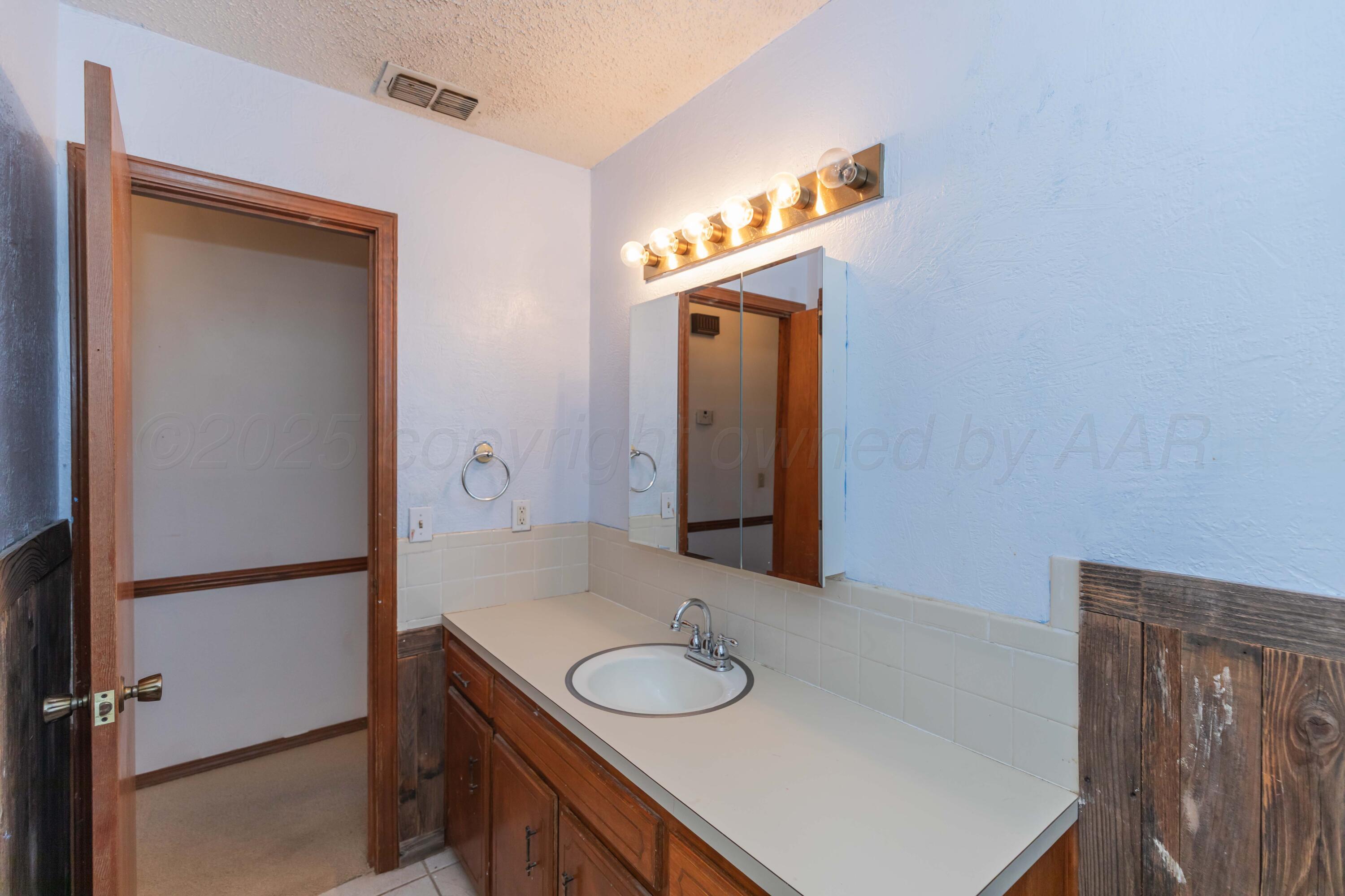 134 Eddie Street Canadian, TX 79014 - Photo 28 of 45 a bathroom with a sink and a mirror